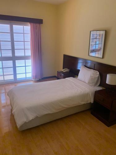 普拉泽里什Casa De Cha Prazeres的卧室设有一张白色大床和一扇窗户。