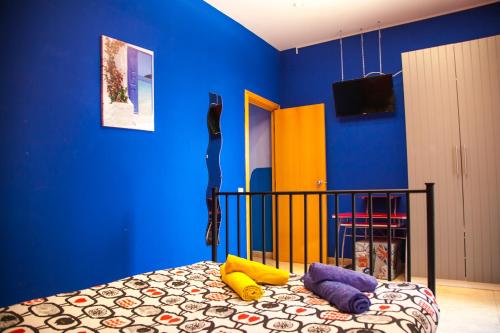巴塞罗那若斯雷欧尼公寓的一间卧室设有蓝色的墙壁和一张带色彩缤纷枕头的床。