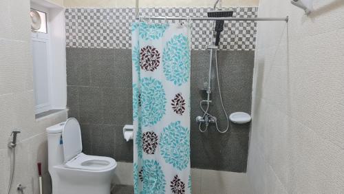 索哈尔Sadaf Hotel Apartments的一间带卫生间和淋浴帘的浴室