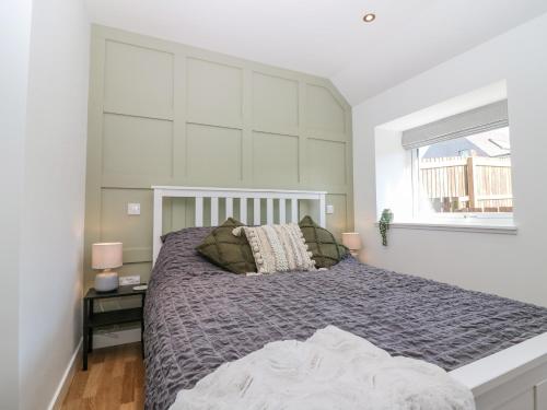 基里缪尔Lindsay Cottage的一间卧室设有一张大床和一个窗户。