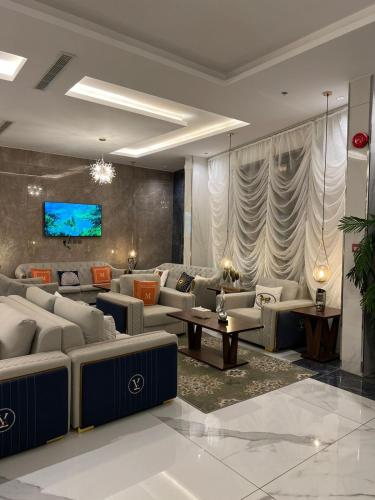 An Nimāşفندق التلال الخضراء的带沙发的客厅和墙上的电视