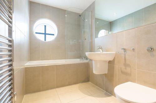 圣艾夫斯Serendipity的一间带水槽和卫生间的浴室以及窗户。