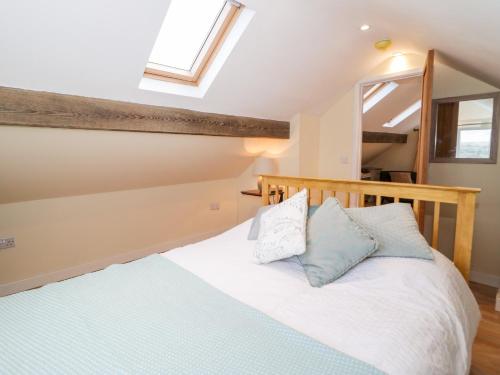 贝图瑟科伊德Bryn Dedwydd Cottage的一间卧室配有一张带蓝色和白色枕头的床
