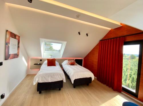 奥伯尔Le Clos du Verger的卧室内的两张床,配有红色窗帘