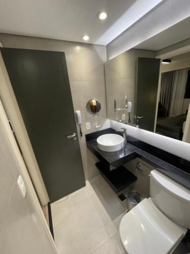 圣保罗Flat particular incrível dentro do hotel M Ibirapuera em Moema的一间带卫生间、水槽和镜子的浴室