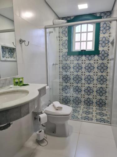 蒂拉登特斯Pousada Candelabro的一间带卫生间、水槽和窗户的浴室