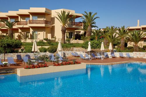 埃亚玛琳娜奈奇多Giannoulis – Santa Marina Beach Hotel的一个带椅子和遮阳伞的游泳池的度假酒店