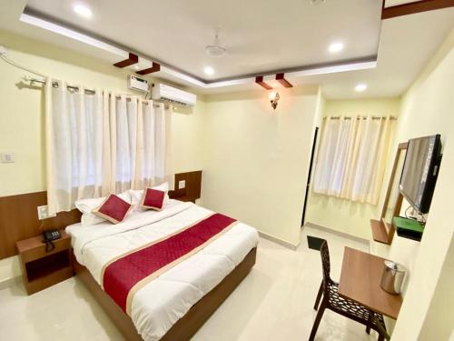波尔沃林Prabhuvihar Residency的一间卧室配有一张床和一台电视
