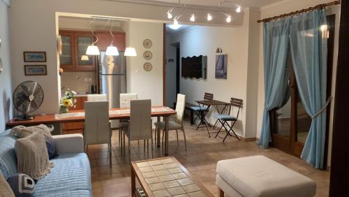 欧拉努波利斯Yulia Guest House的客厅以及带桌子和沙发的厨房。