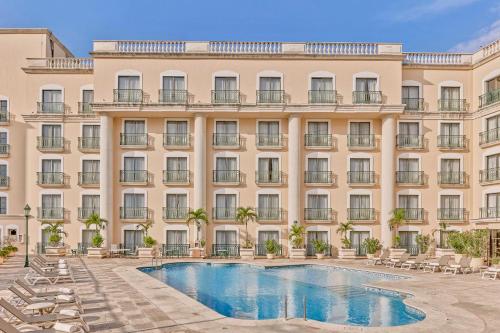 梅里达梅里达美洲庆典酒店的大楼前设有游泳池的酒店
