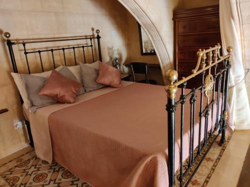 瓦莱塔Cozy Corner House in Valletta - Authentic!的一间卧室配有一张带金属框架的床