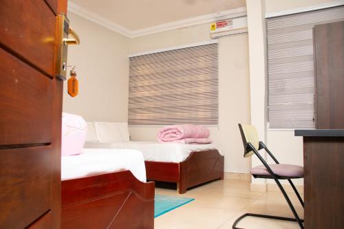 AfwerasiEl-King Home Lodge的一间卧室设有两张床和一个带百叶窗的窗户。