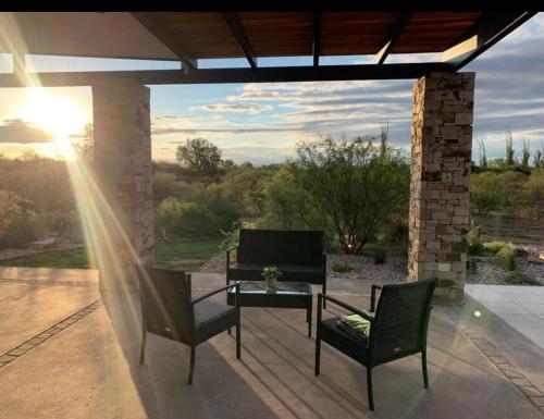圣拉斐尔Casa Pueblo Benegas的庭院设有两把椅子和一张桌子,享有美景。