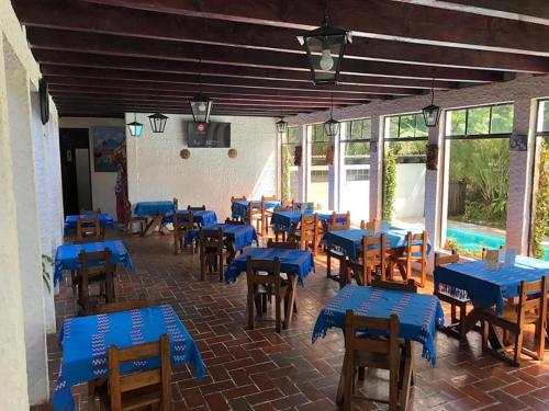 科万Posada Montaña del Quetzal的一间设有蓝色桌椅的房间和一个游泳池