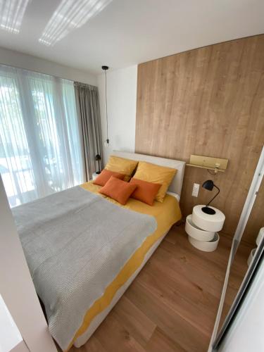 巴拉通雷勒Premium Lelle Waterfront Resort Clyde的一间卧室配有一张带橙色枕头的大床