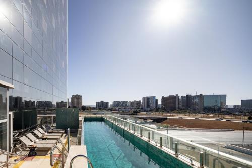 巴西利亚Ramada by Wyndham Brasilia Alvorada的建筑物一侧的游泳池
