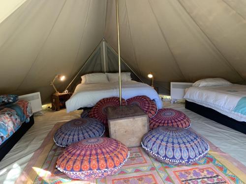 CoodanupLuxury 6 metre Bell Tent & Outdoor Bathroom, WIFI, TV and firepit,的帐篷内的房间配有两张床和三个枕头