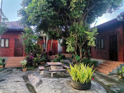 孟丰沙湾孔基欧旅馆的房屋前设有带桌子和长凳的花园
