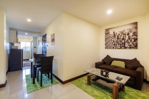 华欣Kanokkan Apartment的客厅配有沙发和桌子