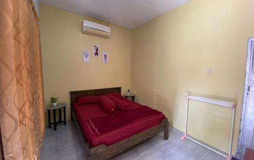 MendutPondok kali oedal的一间在房间内配有红色床的卧室