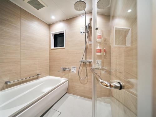 那霸Rakuten STAY Naha-Miebashi Suite Room的带淋浴和白色浴缸的浴室