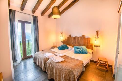 ZigaBehin Batean, espectacular casa rural en pleno corazón del valle Baztán的一间卧室设有两张床和大窗户