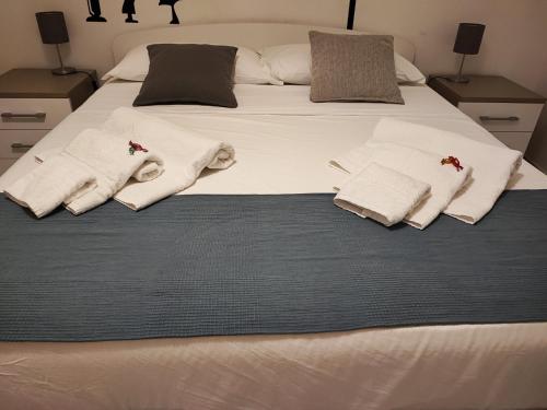 卡塔尼亚mungiBEDdu Apartment的一张带毛巾和枕头的白色床