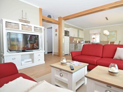 奥特里德维茨Haus Mönchgut - Haushälfte 2 "Findling"的客厅配有红色沙发和电视