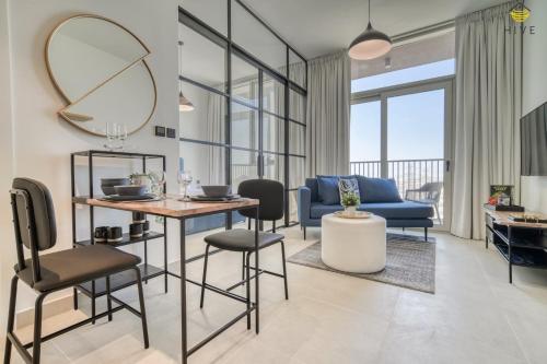 迪拜Lovely 1 Bedroom Apartment in Collective 2.0的客厅配有桌椅和镜子