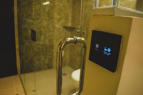 麦克坦Cebu Dulcinea Hotel and Suites-MACTAN AIRPORT HOTEL的带淋浴、水槽和淋浴的浴室