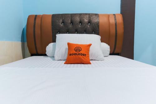 占碑市KoolKost Syariah at Jelutung Jambi的床上有一个橙色枕头