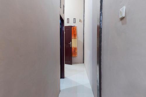 占碑市KoolKost Syariah at Jelutung Jambi的一条空的走廊,有门,一间有白色墙壁的房间