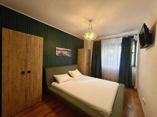 北马马亚-讷沃达里Arcadia Apartament Mamaia Nord的一间卧室配有一张带绿色墙壁的床