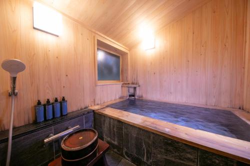 由布市梅园日式旅馆的木墙木房内的热水浴缸