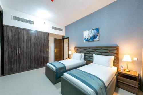 沙迦Luxe Grand Hotel Apartments的酒店客房设有两张床和窗户。