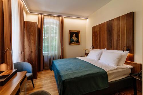 多布尔纳Boutique Hotel Dobrna - Terme Dobrna的配有一张床和一张书桌的酒店客房