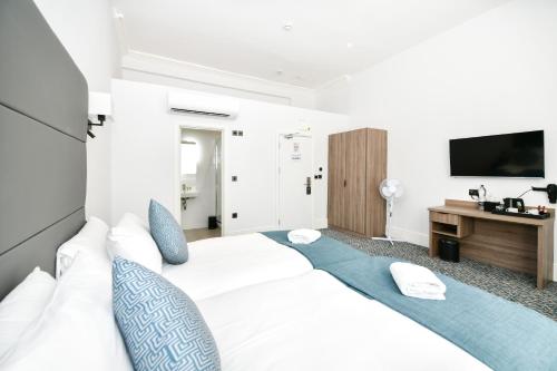 伦敦The J Hyde Park的卧室配有带蓝色枕头的大型白色床