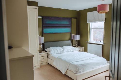 马特洛克The Grange Matlock Bath的卧室配有白色的床和窗户。
