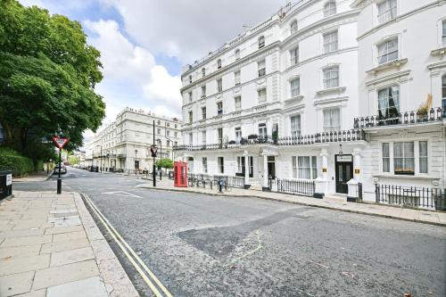 伦敦The J Hyde Park的一条空荡荡的城市街道,上面有白色的建筑和红色的电话亭