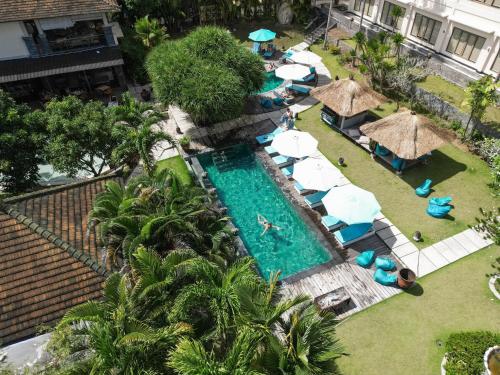 乌鲁瓦图巴厘岛山谷S度假酒店的享有带遮阳伞和椅子的度假村游泳池的空中景致