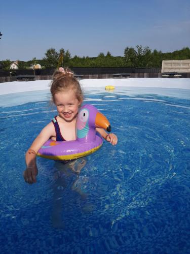 弗瓦迪斯瓦沃沃Wichrowe Domki Plus的游泳池里水中的一个小女孩