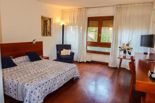 巴勒莫玛尔贝拉公寓式酒店的一间卧室配有一张床、一张书桌和一个窗户。