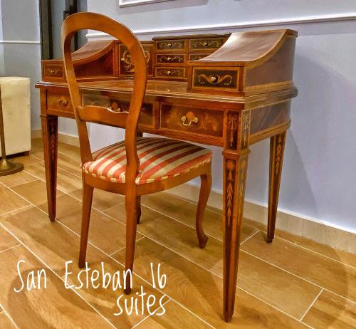 塞维利亚SUITES SAN ESTEBAN 16 Real的一张木桌,桌子旁边摆放着椅子