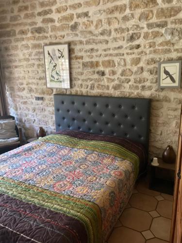 Villaines-les-PrévôtesLa Luterne的一间卧室配有一张砖墙床
