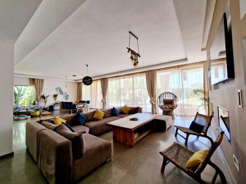 马拉喀什Villa Le Clos de l'Atlas的客厅配有沙发和桌子