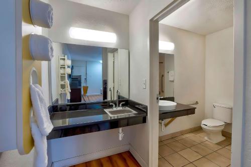 盖恩斯维尔美洲最有价值旅馆-75号州际公路北盖恩斯维尔的一间带水槽、卫生间和镜子的浴室