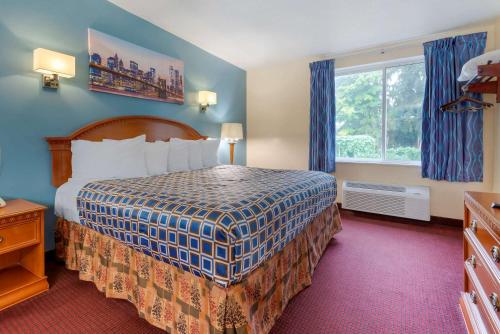 新帕尔茨Rodeway Inn & Suites New Paltz- Hudson Valley的酒店客房设有床和窗户。