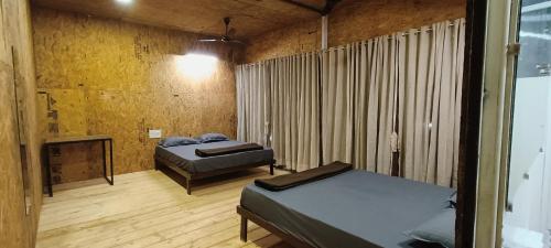 潘奇加尼The Tribe Agrotourism, Wai mahabaleshwar的客房设有两张床和壁炉。