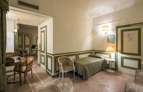 廖洛泰尔梅泰尔梅大酒店的卧室配有一张床和一张桌子及椅子