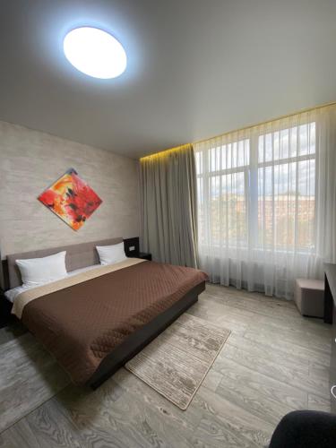 波尔塔瓦Hotel Atmosphere的一间卧室设有一张床和一个大窗户